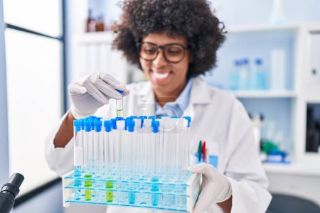 Téléchargez les photos : Femme scientifique afro-américaine tenant des éprouvettes en laboratoire - en image libre de droit