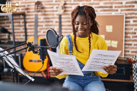 Téléchargez les photos : African american woman musician smiling confident singing song at music studio - en image libre de droit