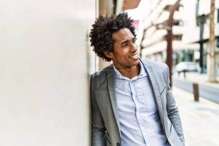 Foto de Joven hombre de negocios afroamericano sonriendo feliz de pie en la ciudad. - Imagen libre de derechos