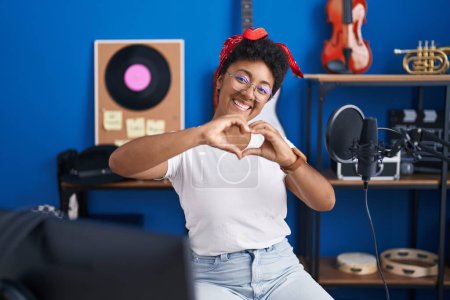 Téléchargez les photos : African american woman musician doing heart gesture with hands at music studio - en image libre de droit