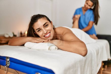 Téléchargez les photos : Deux femmes thérapeute et patient ayant séance de massage massant les jambes au centre de beauté - en image libre de droit