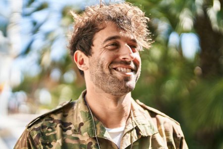 Foto de Joven soldado del ejército sonriendo confiado en el parque - Imagen libre de derechos