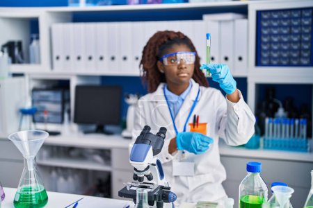 Téléchargez les photos : African american woman scientist holding test tube at laboratory - en image libre de droit