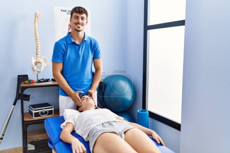 Téléchargez les photos : Man and woman wearing physiotherpy uniform having reiki therapy session at clinic - en image libre de droit