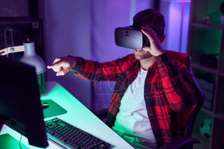 Téléchargez les photos : Young caucasian man streamer playing video game using virtual reality glasses at gaming room - en image libre de droit