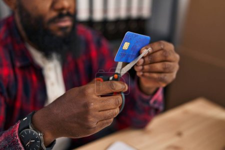 Foto de Joven afroamericano hombre comercio electrónico trabajador de negocios corte tarjeta de crédito en la oficina - Imagen libre de derechos