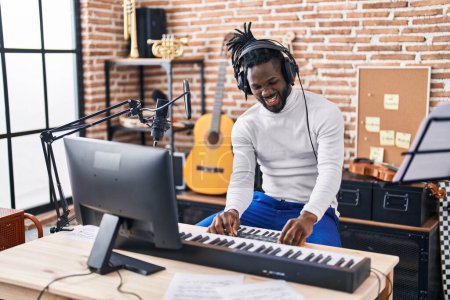 Foto de Músico afroamericano tocando el teclado de piano en el estudio de música - Imagen libre de derechos