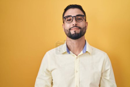 Téléchargez les photos : Jeune homme hispanique portant des vêtements de travail et des lunettes avec les mains jointes et les doigts croisés souriant détendu et joyeux. succès et optimisme - en image libre de droit