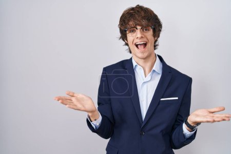 Téléchargez les photos : Entreprise hispanique jeune homme portant des lunettes souriant gai offrant des mains donnant assistance et acceptation. - en image libre de droit