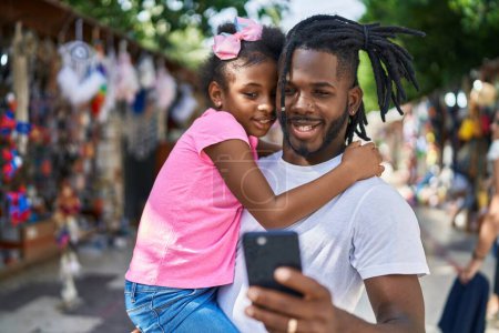 Téléchargez les photos : Father and daughter smiling confident make selfie by smartphone at street market - en image libre de droit
