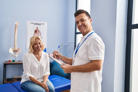 Photo for Middle age man and woman physiotherapist and patient having rehab session at physiotherapy clinic - Royalty Free Image