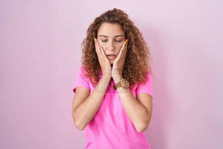 Photo for Young caucasian woman standing over pink background tired hands covering face, depression and sadness, upset and irritated for problem - Royalty Free Image
