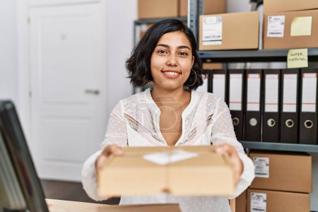 Photo for Young latin woman ecommerce business worker holding package order at office - Royalty Free Image