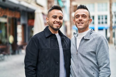 Foto de Dos hombres pareja sonriendo confiados de pie juntos en la calle - Imagen libre de derechos