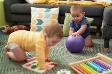 Foto de Dos niños jugando con juguetes sentados en el suelo en casa - Imagen libre de derechos