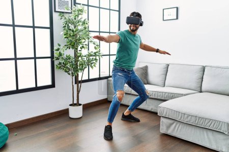 Photo for Young arab man smiling confident playing with vr goggles at home - Royalty Free Image