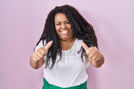 Photo for Plus size hispanic woman standing over pink background approving doing positive gesture with hand, thumbs up smiling and happy for success. winner gesture. - Royalty Free Image