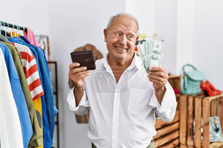 Senior man customer holding dollars and wallet at clothing store