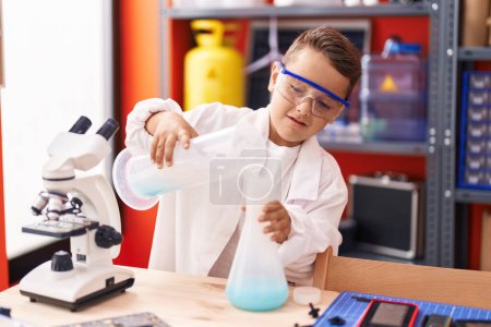 Photo for Adorable hispanic toddler student smiling confident pouring liquid on test tube at classroom - Royalty Free Image