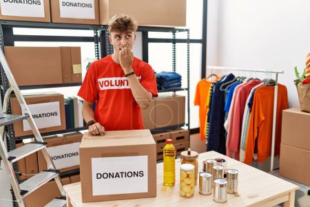 Photo for Young caucasian man volunteer holding donations box looking stressed and nervous with hands on mouth biting nails. anxiety problem. - Royalty Free Image