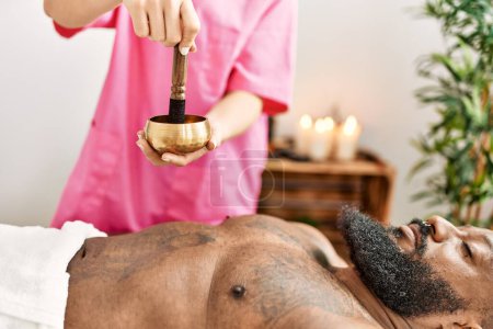 Téléchargez les photos : Jeune homme afro-américain ayant un traitement d'aromathérapie au centre de beauté - en image libre de droit