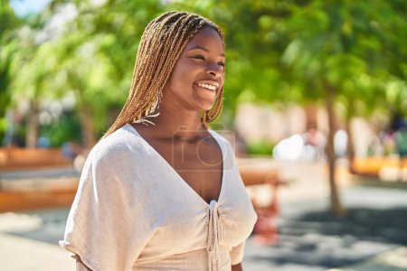 Téléchargez les photos : Afro-américaine femme souriant confiant regardant vers le côté au parc - en image libre de droit