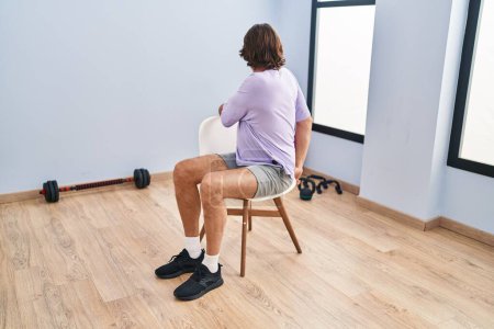 Photo for Middle age man sitting on chair stretching at sport center - Royalty Free Image