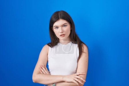 Photo for Young caucasian woman standing over blue background looking sleepy and tired, exhausted for fatigue and hangover, lazy eyes in the morning. - Royalty Free Image