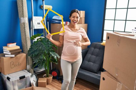 Photo for Young pregnant woman moving to a new home smiling and laughing hard out loud because funny crazy joke. - Royalty Free Image