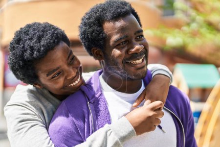 Téléchargez les photos : African american man and woman couple smiling confident hugging each other at street - en image libre de droit