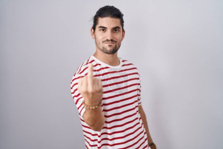 Foto de Hispanic man with long hair standing over isolated background showing middle finger, impolite and rude fuck off expression - Imagen libre de derechos
