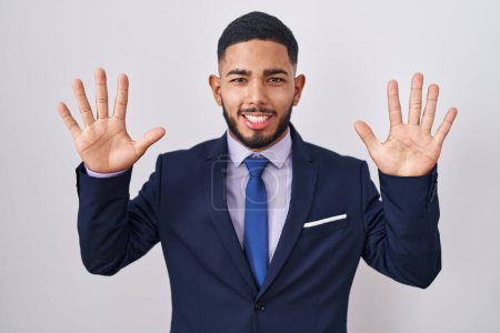 Photo for Young hispanic man wearing business suit and tie showing and pointing up with fingers number ten while smiling confident and happy. - Royalty Free Image