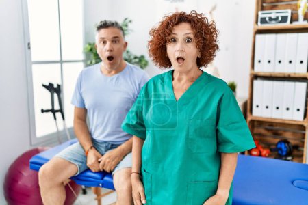 Téléchargez les photos : Physiotherapy woman working at pain recovery clinic with patient scared and amazed with open mouth for surprise, disbelief face - en image libre de droit