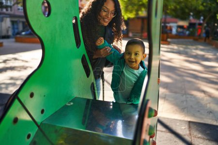 Photo for Mother and son playing on slide at park - Royalty Free Image
