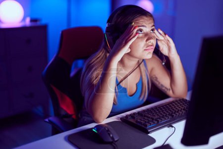 Foto de Joven hermosa mujer hispana streamer estresado usando computadora en sala de juegos - Imagen libre de derechos