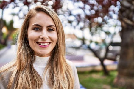 Téléchargez les photos : Jeune femme blonde souriante confiante au parc - en image libre de droit