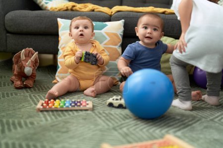 Foto de Dos niños jugando con juguetes sentados en el suelo en casa - Imagen libre de derechos