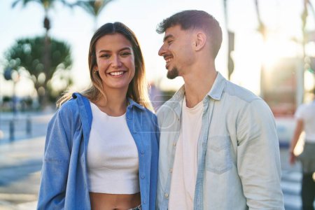 Téléchargez les photos : Jeune homme et femme couple souriant confiant debout ensemble dans la rue - en image libre de droit