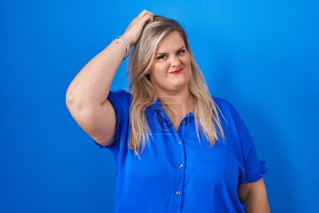 Photo for Caucasian plus size woman standing over blue background confuse and wonder about question. uncertain with doubt, thinking with hand on head. pensive concept. - Royalty Free Image
