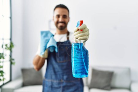 Photo for Young hispanic man smiling confident holding sprayer at home - Royalty Free Image