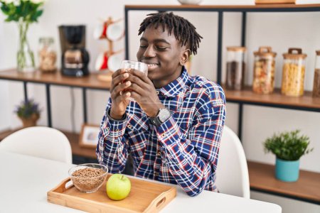 Foto de Hombre afroamericano desayunando sano sentado en la mesa en casa - Imagen libre de derechos