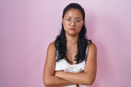 Téléchargez les photos : Asian young woman standing over pink background skeptic and nervous, disapproving expression on face with crossed arms. negative person. - en image libre de droit