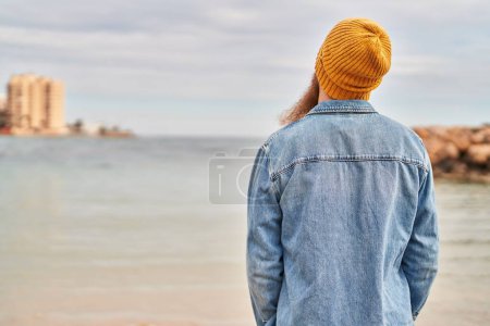 Téléchargez les photos : Jeune rousse homme debout sur la vue de dos au bord de la mer - en image libre de droit