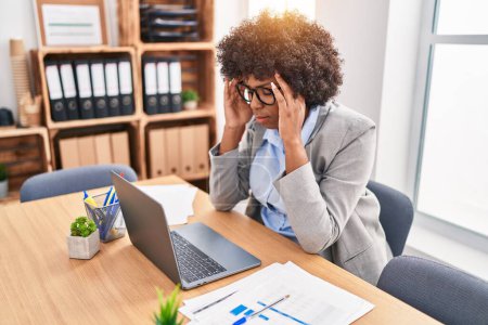 Foto de Trabajadora de negocios afroamericana estresada usando laptop en oficina - Imagen libre de derechos