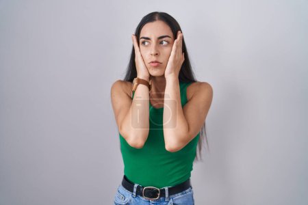 Foto de Young woman standing over isolated background tired hands covering face, depression and sadness, upset and irritated for problem - Imagen libre de derechos