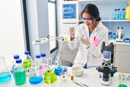 Photo for Young chinese woman wearing scientist uniform working at laboratory - Royalty Free Image
