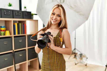 Téléchargez les photos : Jeune photographe femme caucasienne tenant studio photo appareil photo professionnel - en image libre de droit