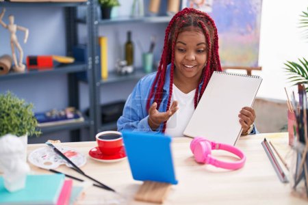 Téléchargez les photos : African american woman artist having video call showing draw at art studio - en image libre de droit