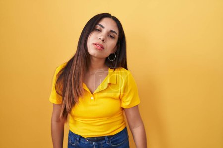 Photo for Young arab woman standing over yellow background looking sleepy and tired, exhausted for fatigue and hangover, lazy eyes in the morning. - Royalty Free Image