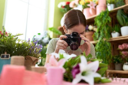 Photo for Young beautiful woman florist make photo to bouquet of flowers at flower shop - Royalty Free Image